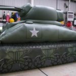 Man adding artwork to giant inflatable tank