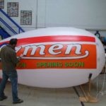 Man painting Ozmen air ship to promote new location