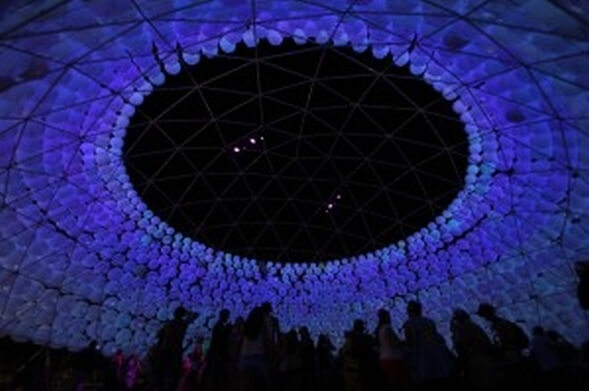 people at night inside lit dome of inflatable spheres