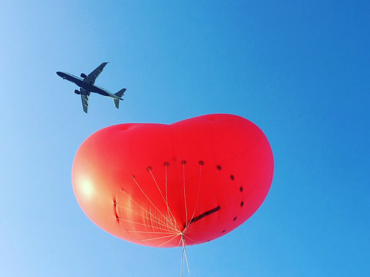 Aeroplane flying above inflatable heart