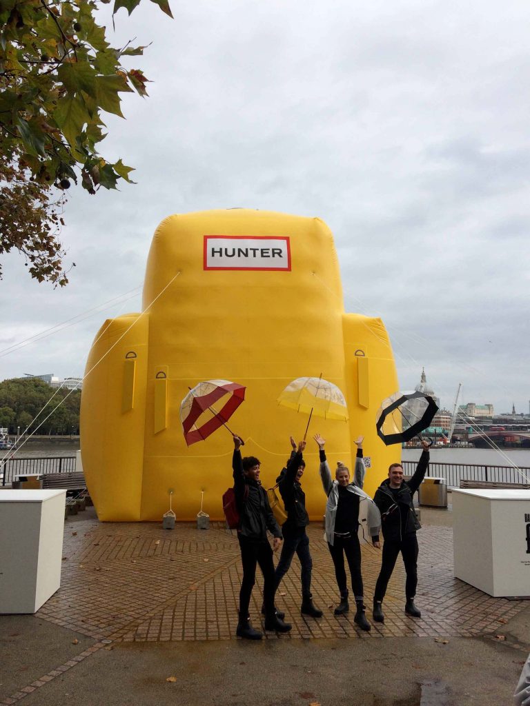 4 people with umbrellas by Hunter backpack inflatable